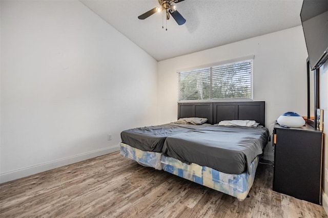 bedroom featuring ceiling fan, lofted ceiling, and hardwood / wood-style floors