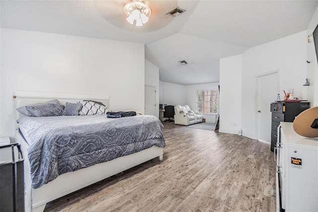 bedroom featuring hardwood / wood-style floors, vaulted ceiling, and ceiling fan