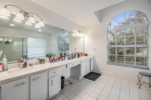 bathroom featuring vanity, a shower with shower door, tile patterned flooring, and plenty of natural light