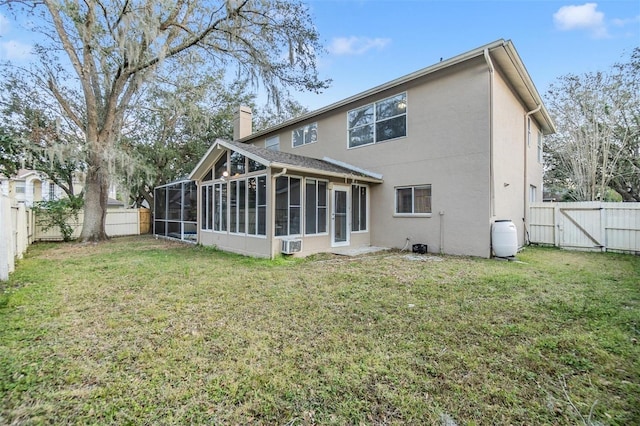 back of property with a yard and a sunroom