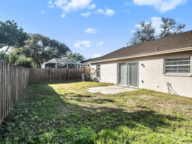 view of yard with central AC unit and a patio area