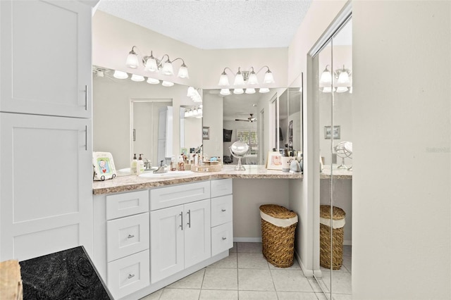 bathroom with vanity, tile patterned flooring, and a textured ceiling