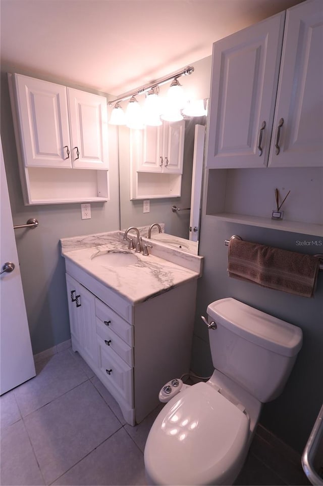 bathroom with tile patterned flooring, vanity, and toilet