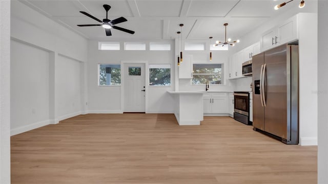 kitchen with pendant lighting, stainless steel appliances, light hardwood / wood-style floors, white cabinets, and ceiling fan with notable chandelier