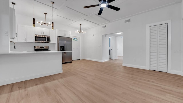 kitchen featuring pendant lighting, appliances with stainless steel finishes, light wood-type flooring, and white cabinets