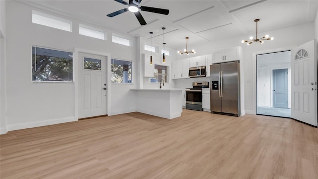 kitchen with white cabinetry, stainless steel appliances, kitchen peninsula, and light wood-type flooring