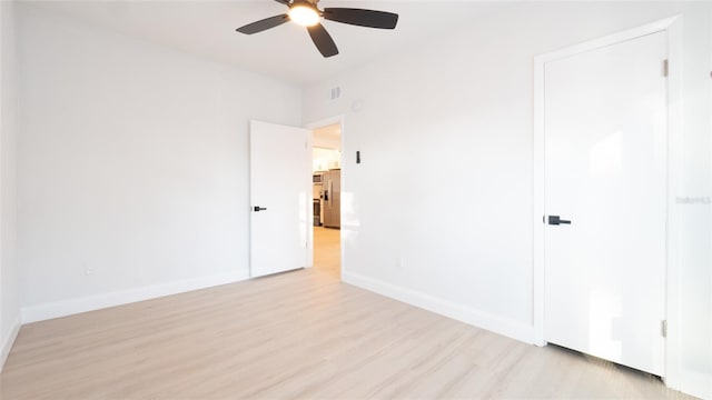 spare room with ceiling fan and light wood-type flooring