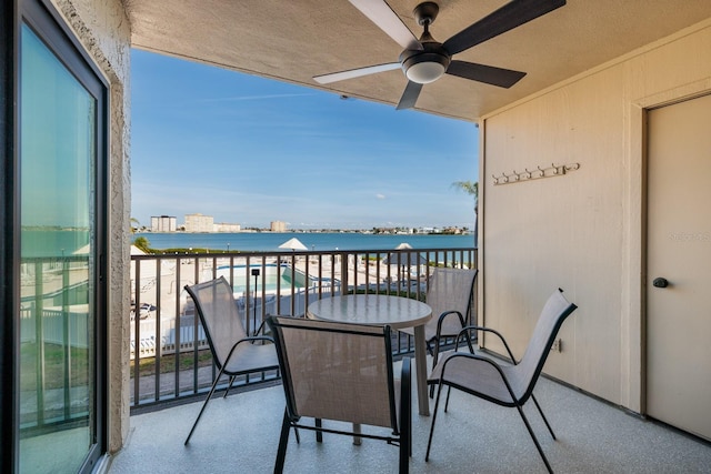 balcony featuring a water view and ceiling fan