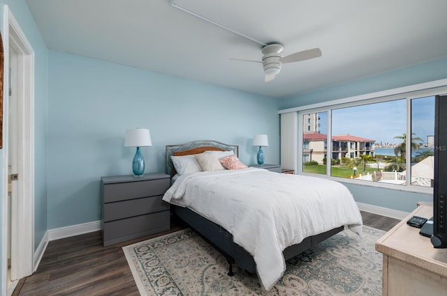 bedroom with dark hardwood / wood-style flooring and ceiling fan