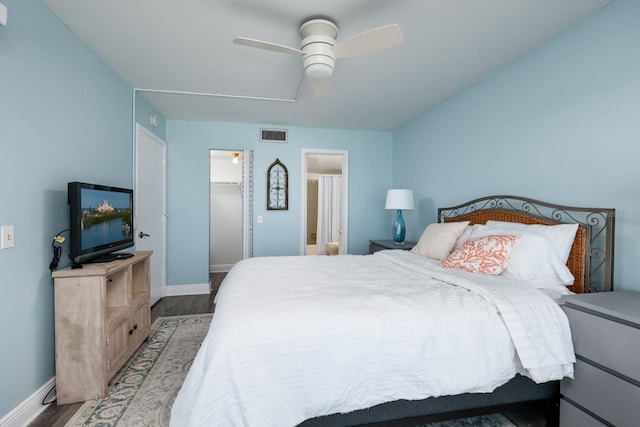 bedroom featuring hardwood / wood-style flooring, ceiling fan, a spacious closet, and ensuite bath