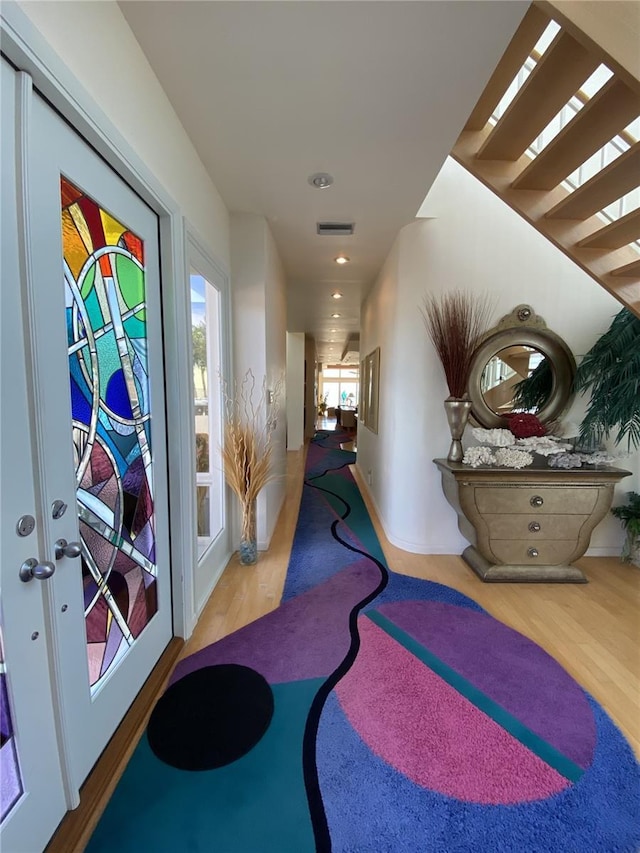 corridor with hardwood / wood-style flooring