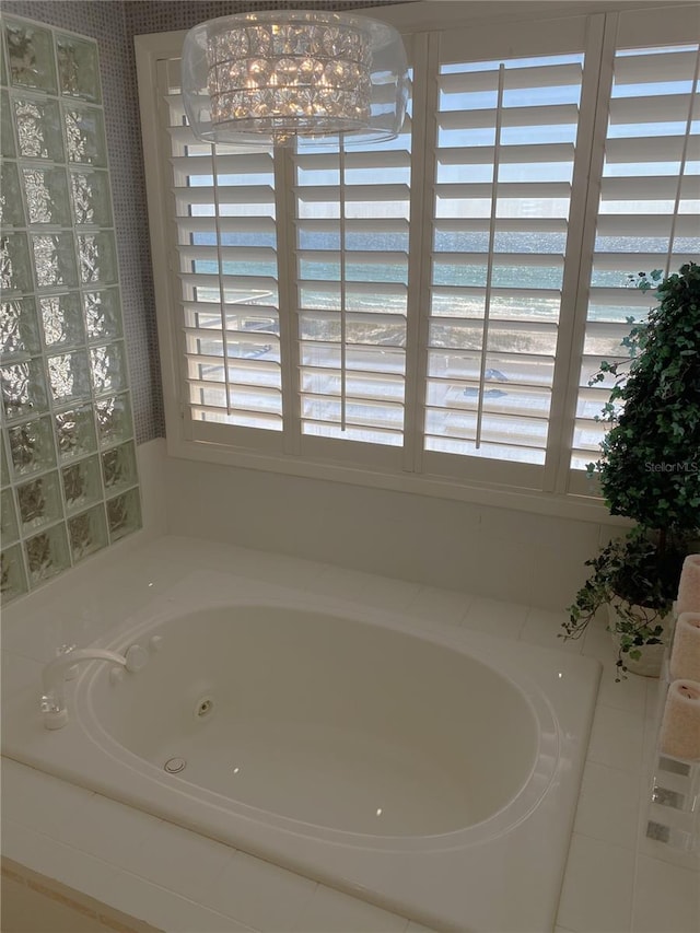 bathroom featuring a view of the beach, tiled bath, and a water view