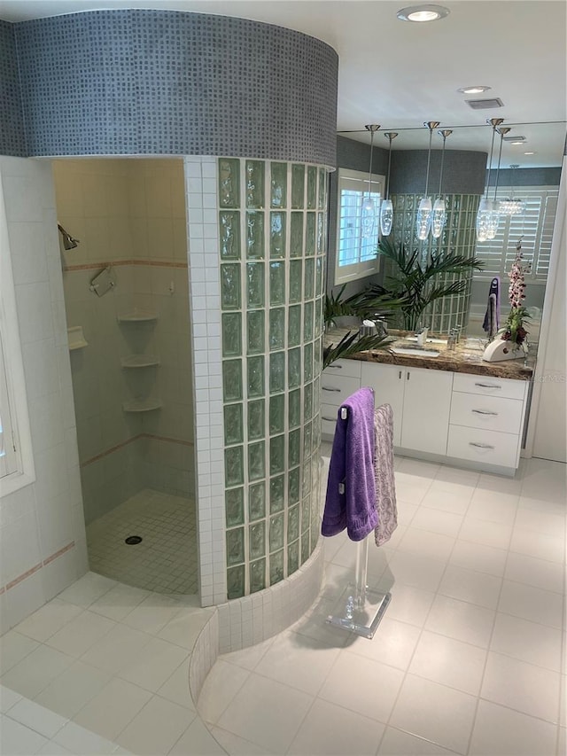 bathroom featuring vanity, tile patterned flooring, and tiled shower