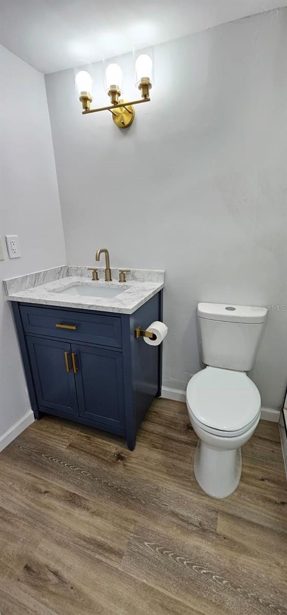 bathroom with vanity, hardwood / wood-style floors, and toilet