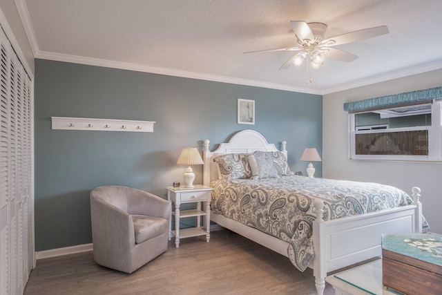 bedroom featuring hardwood / wood-style floors, ornamental molding, a textured ceiling, and ceiling fan