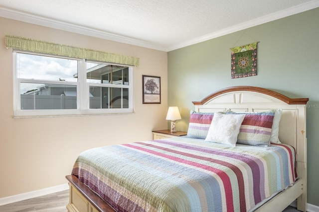 bedroom with ornamental molding, a textured ceiling, and light hardwood / wood-style flooring