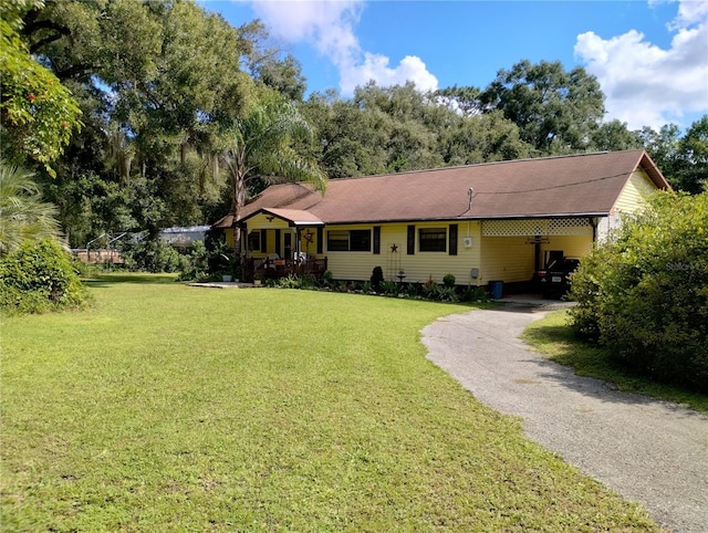 ranch-style house with a front yard and a carport