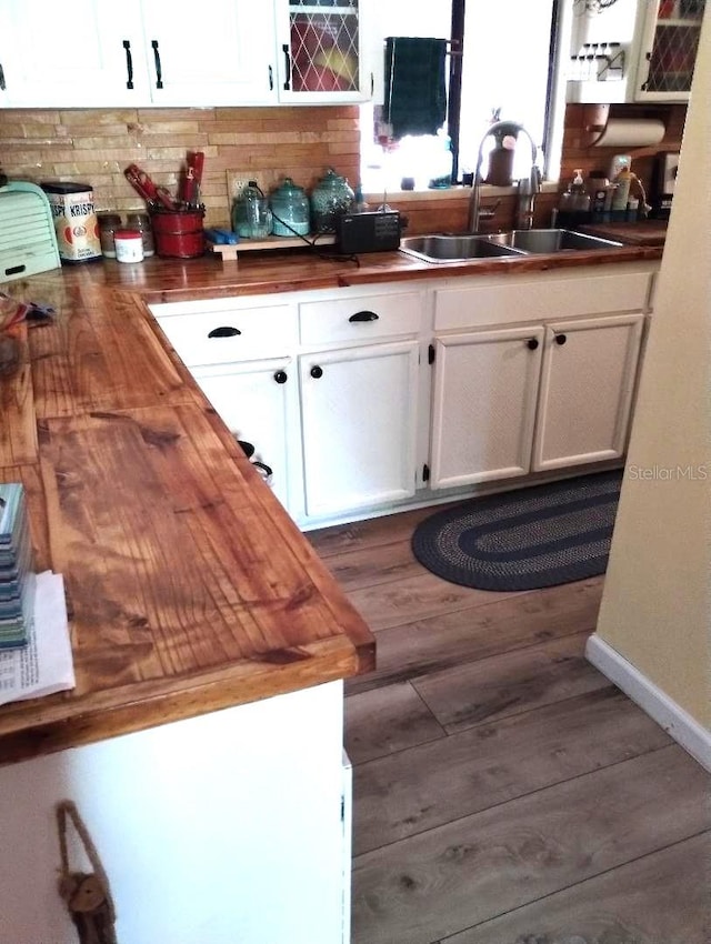 kitchen with white cabinetry, dark wood-type flooring, butcher block counters, and sink