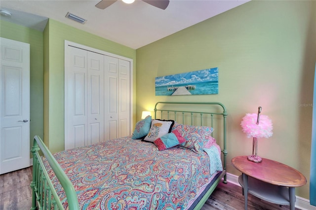 bedroom with ceiling fan, a closet, wood finished floors, and visible vents