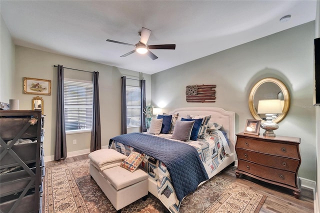 bedroom featuring wood finished floors, a ceiling fan, and baseboards