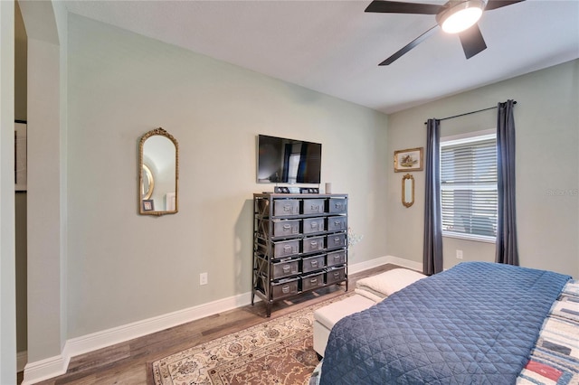 bedroom featuring a ceiling fan, baseboards, and wood finished floors