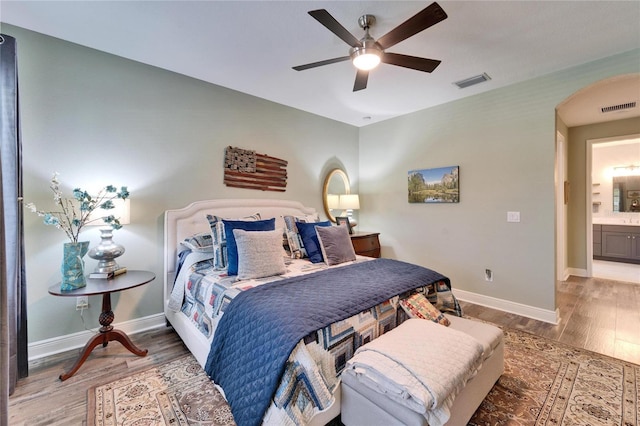 bedroom with wood finished floors, visible vents, and baseboards