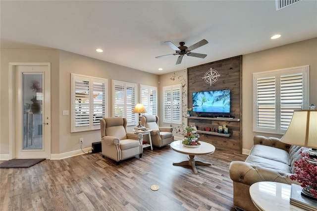 living room featuring recessed lighting, visible vents, baseboards, and wood finished floors