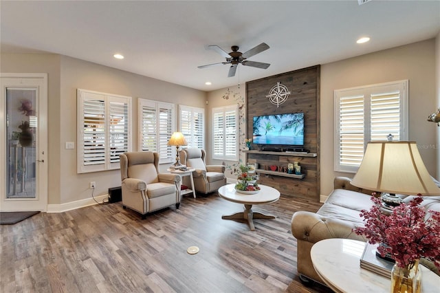 living room featuring baseboards, wood finished floors, a ceiling fan, and recessed lighting