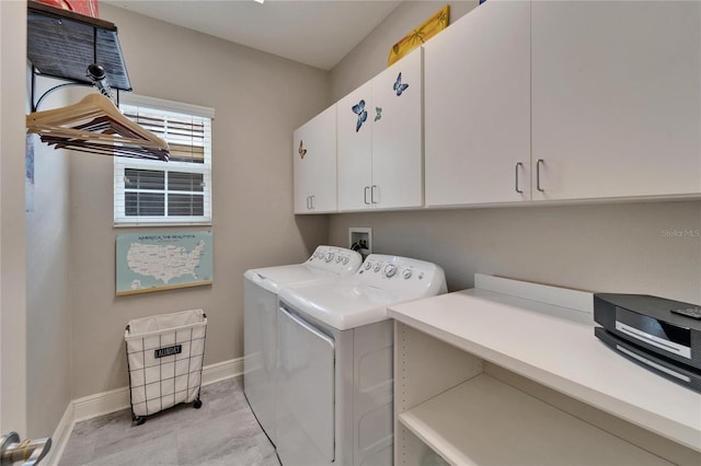 washroom with cabinet space, washing machine and dryer, and baseboards