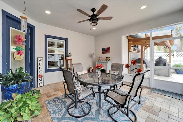 dining area featuring a sunroom, recessed lighting, a ceiling fan, and stone tile floors