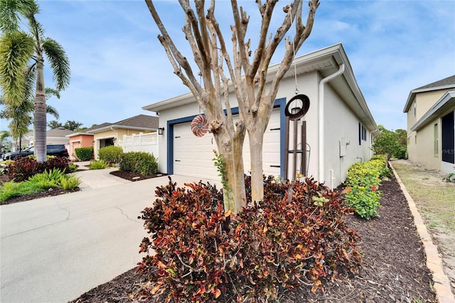 view of front facade with driveway, an attached garage, and stucco siding