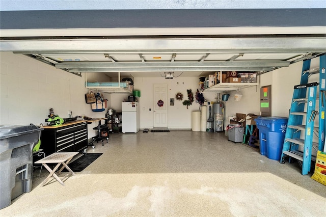 garage with gas water heater, freestanding refrigerator, and concrete block wall