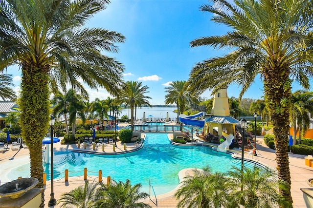 pool with a water slide and a patio area