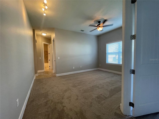 spare room featuring carpet floors and ceiling fan