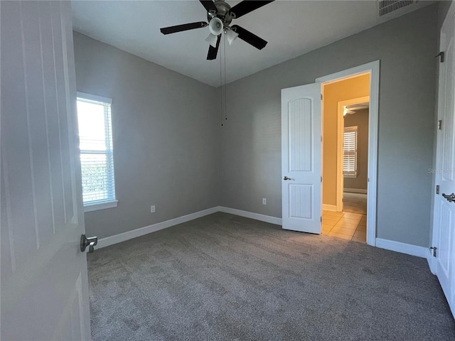 unfurnished bedroom featuring light carpet and ceiling fan