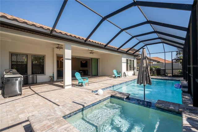 view of swimming pool with ceiling fan, a patio, and glass enclosure