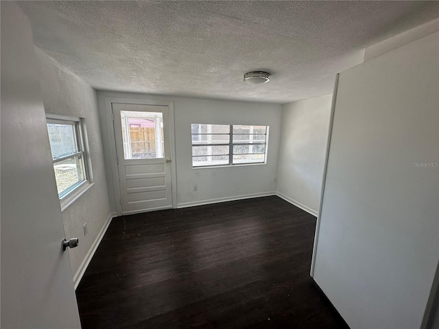 unfurnished room featuring dark hardwood / wood-style floors and a textured ceiling