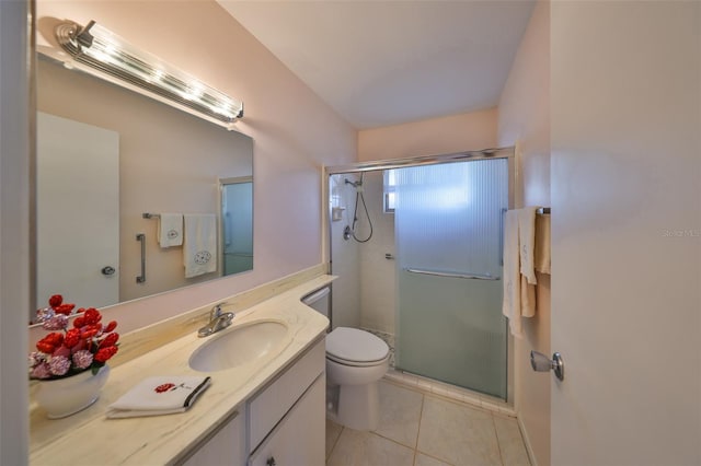 bathroom featuring vanity, toilet, a shower with shower door, and tile patterned flooring