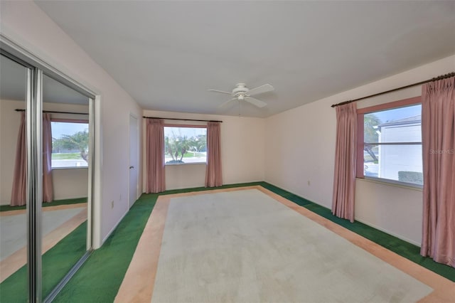 spare room featuring dark carpet and ceiling fan