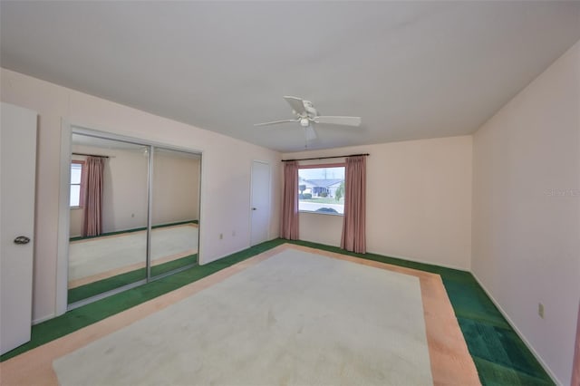 carpeted empty room with a wealth of natural light and ceiling fan