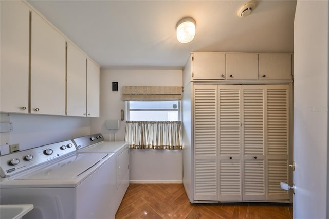 laundry room with parquet flooring, cabinets, and separate washer and dryer