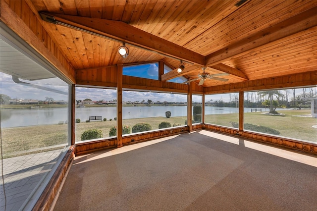 unfurnished sunroom featuring ceiling fan, lofted ceiling with beams, wooden ceiling, and a water view