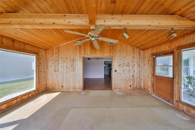 carpeted spare room with vaulted ceiling with beams, a wealth of natural light, and wooden walls