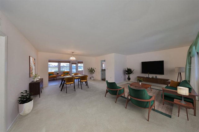 carpeted living room featuring an inviting chandelier