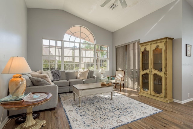 living area with vaulted ceiling, wood finished floors, visible vents, and a ceiling fan