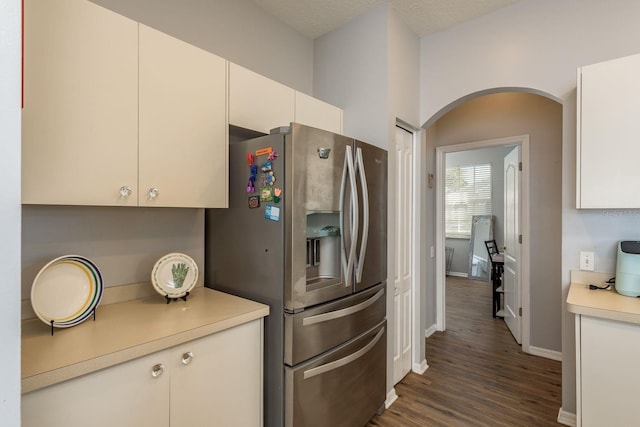 kitchen featuring white cabinets, light countertops, dark wood-type flooring, and stainless steel fridge with ice dispenser