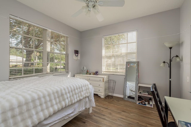 bedroom featuring wood finished floors, a ceiling fan, and baseboards