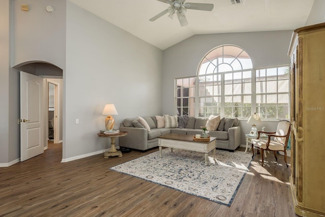 living room with arched walkways, dark wood finished floors, visible vents, ceiling fan, and baseboards