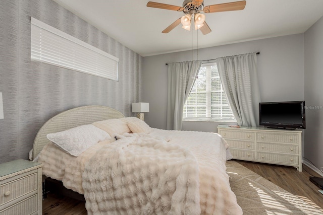 bedroom featuring baseboards, a ceiling fan, and wood finished floors