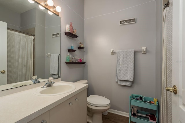 bathroom with visible vents, baseboards, toilet, wood finished floors, and vanity